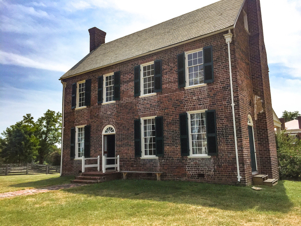 Two-story brick building with eight windows and a small porch