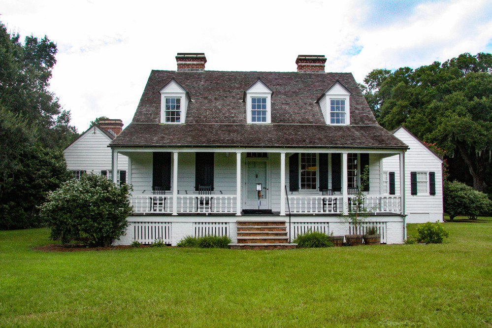 Historic farm house with a prominent porch and two wings