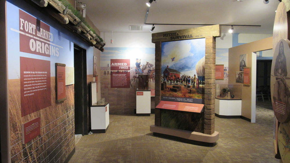 Museum gallery with exhibit text on the wall to the left and a display panel in the center.