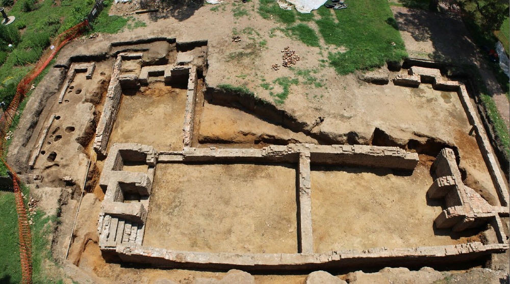 A photo from above looking at that ground and there is a brick outline of a house that has been dug up. The house foundation includes 5 rooms in a rough u-shape.