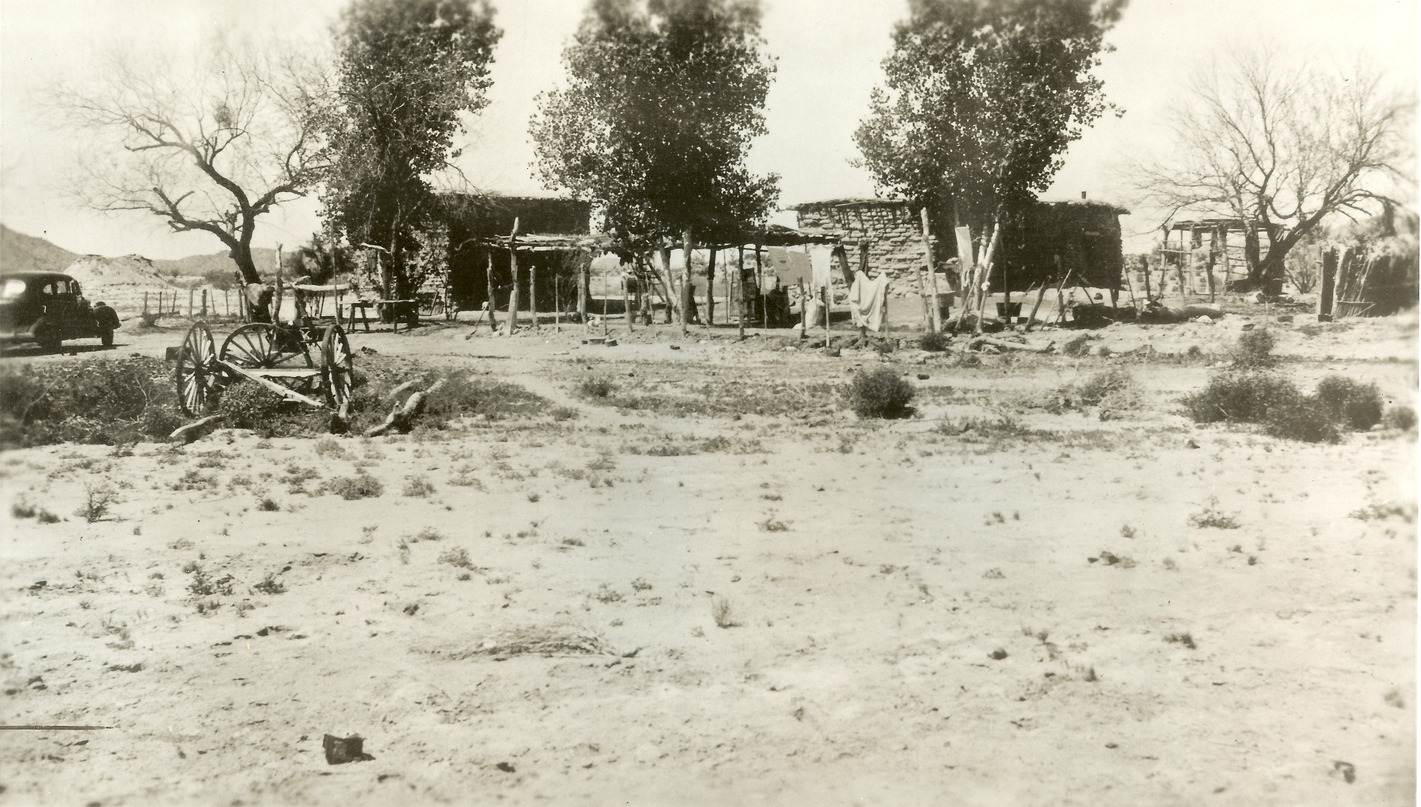 The Orozco family's adobe homes, ramadas, and shade trees near the banks of Quitobaquito Springs. A small buggy car and wagon are visible in the middle left.